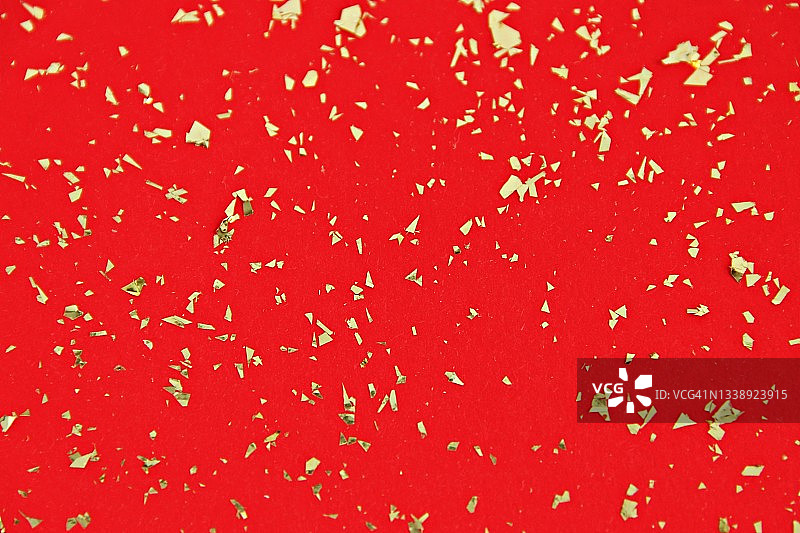 红色背景上的金色纸屑图片素材