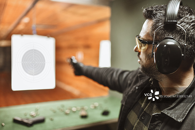 男人尝试单手射击左轮手枪图片素材