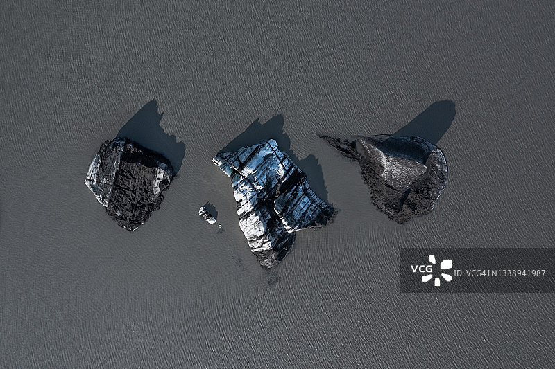 从正上方看到的并排漂浮的三个冰山及其阴影，冰岛图片素材