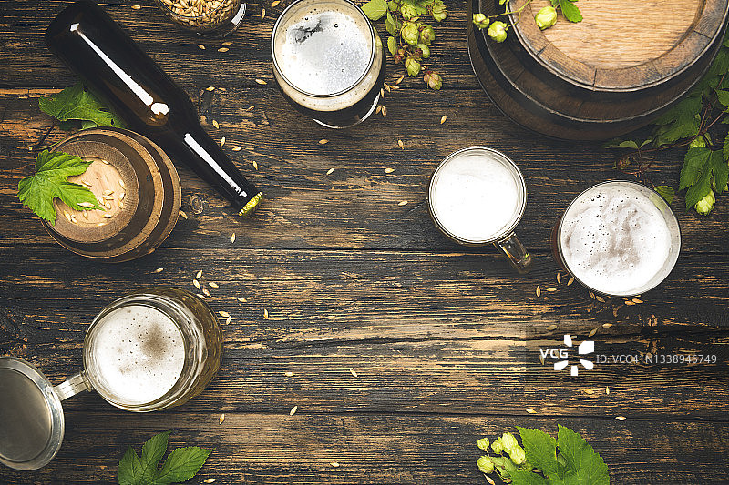 木桌上的冰镇啤酒与泡沫图片素材