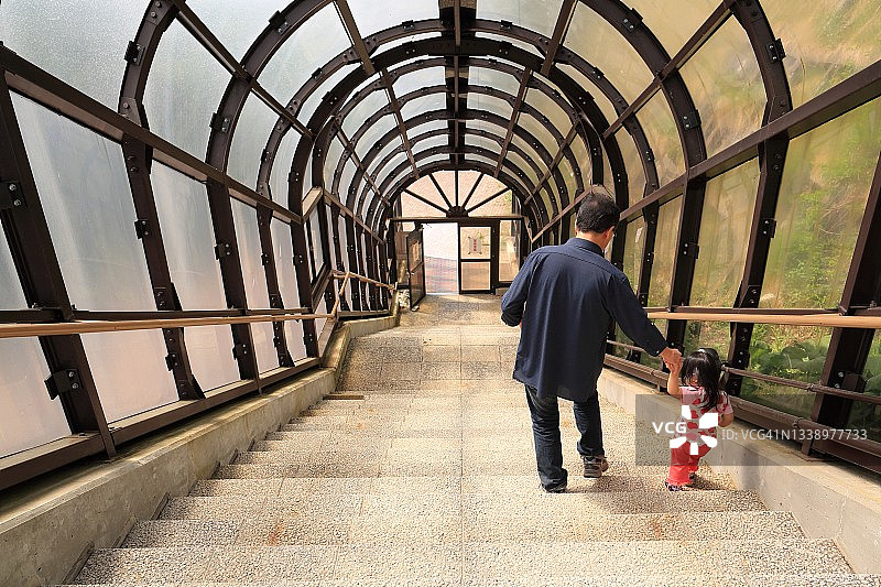 父亲照顾孩子下楼梯图片素材