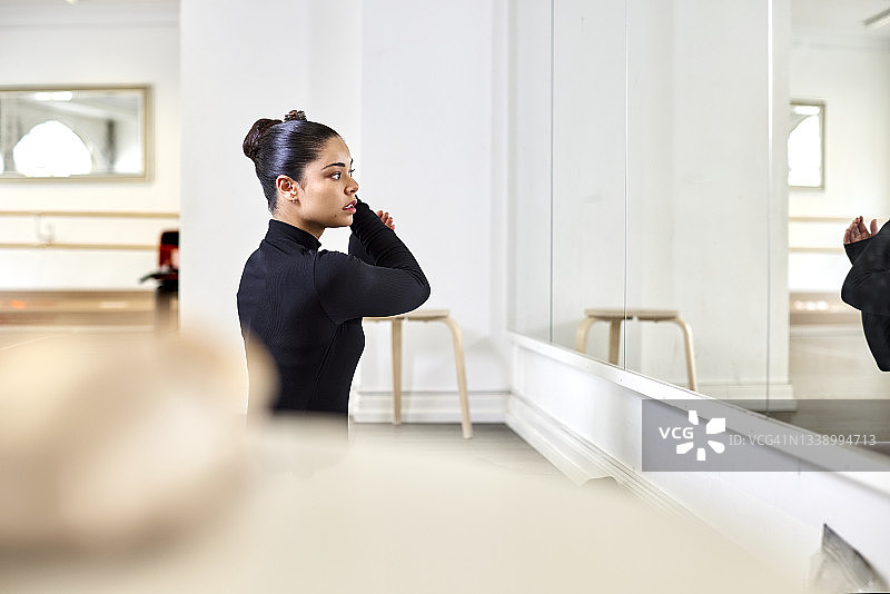 年轻女人在芭蕾舞工作室做头发图片素材