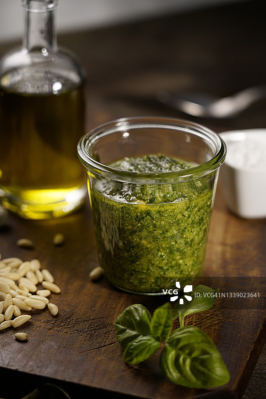 罗勒青酱的配料：传统利古里亚新鲜酱汁，含松子、大蒜、新鲜罗勒、特级初榨橄榄油、帕尔马干酪和佩科里诺奶酪，背景为木质，产自意大利利古里亚图片素材