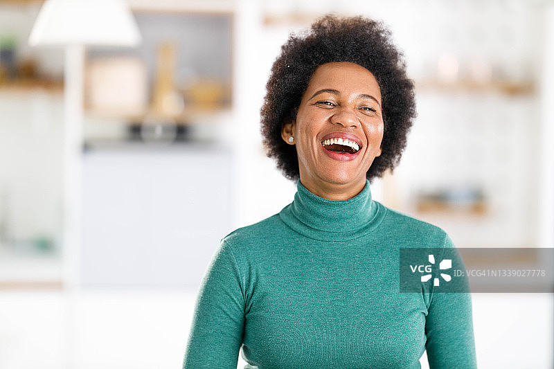 快乐的非裔美国女人在家大笑图片素材