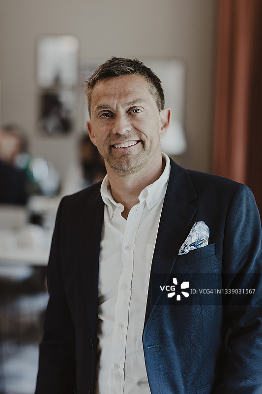 公司办公室里微笑的男企业家肖像图片素材