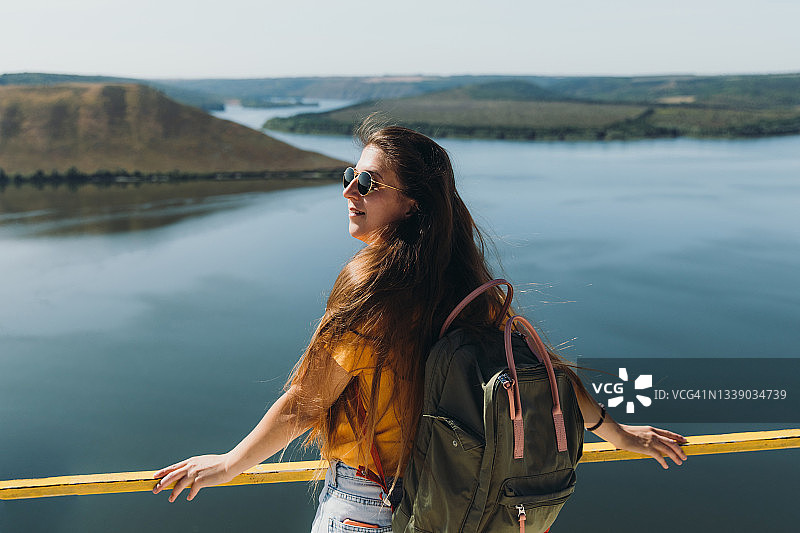 女背包客在高处欣赏湖光山色图片素材