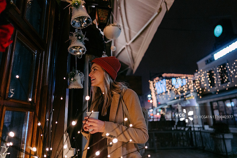 寒冷的冬夜里年轻女人喝着热饮图片素材