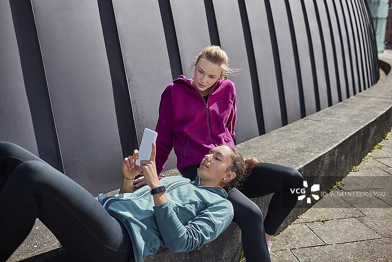 两名年轻女子休息时使用智能手机图片素材