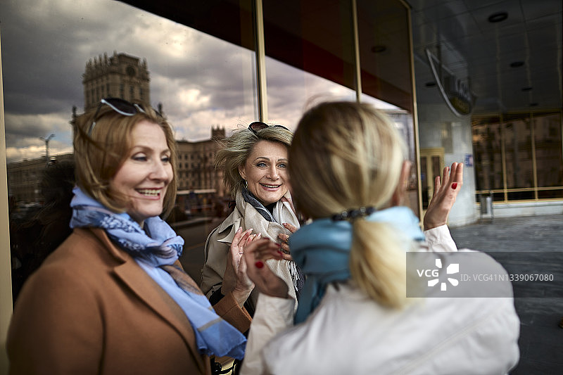 三位快乐的中年女性朋友在城市相遇图片素材