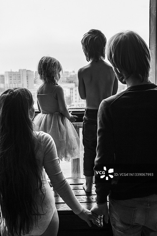 父亲母亲和两个孩子窗边眺望图片素材