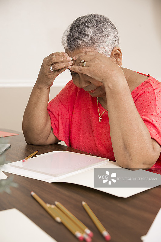 商人坐在办公桌前，为决策苦恼图片素材