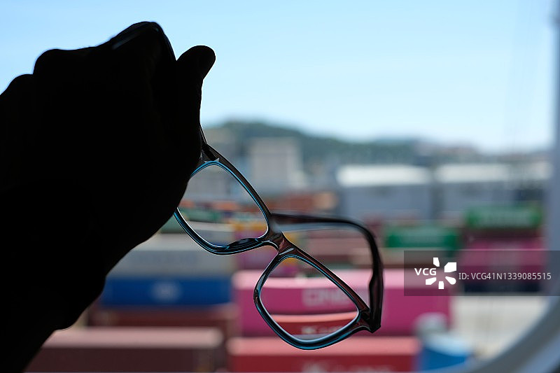 手持酒杯与港口集装箱背景剪影图片素材