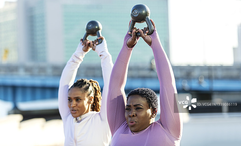 在城市里用壶铃锻炼的非裔美国女人图片素材