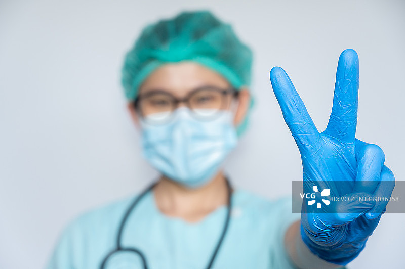 医疗人员在医院工作时做出V字手势（胜利手势）的局部照片图片素材