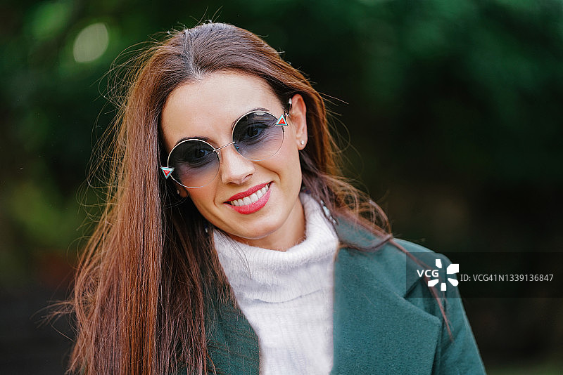 佩戴太阳镜和冬装的年轻女子肖像图片素材