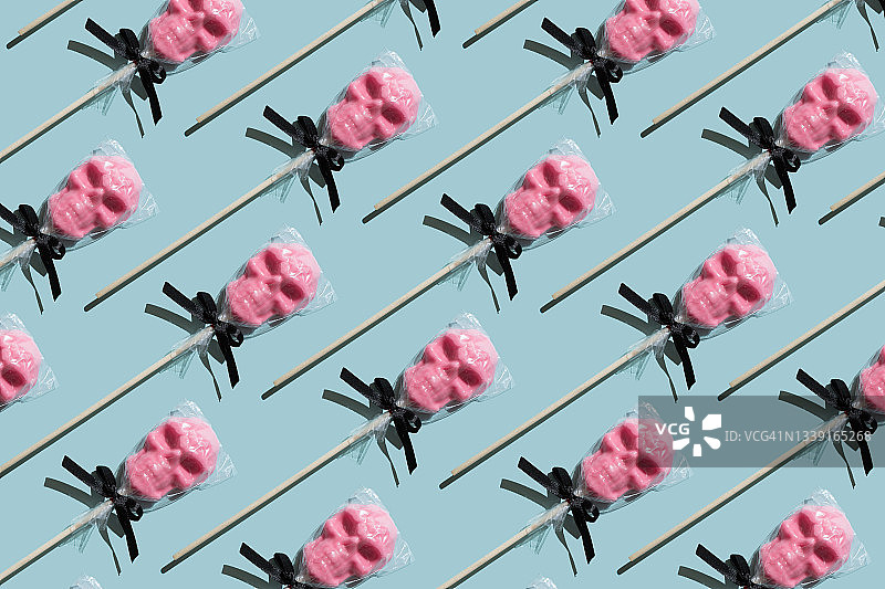 蓝色背景上的骷髅糖果图案万圣节主题图片素材