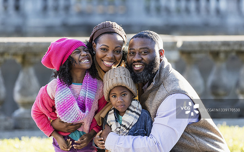 在阳光明媚的秋日公园里的非裔美国家庭图片素材