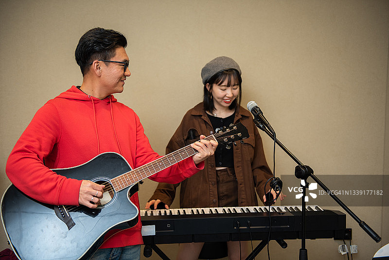 男人和女人在音乐工作室弹吉他和键盘图片素材