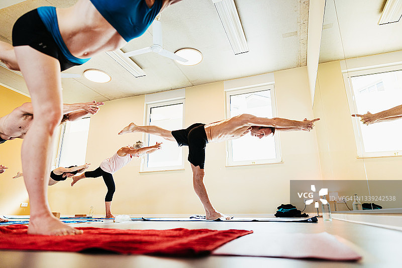 男人在高温瑜伽课上熟练地表演姿势图片素材