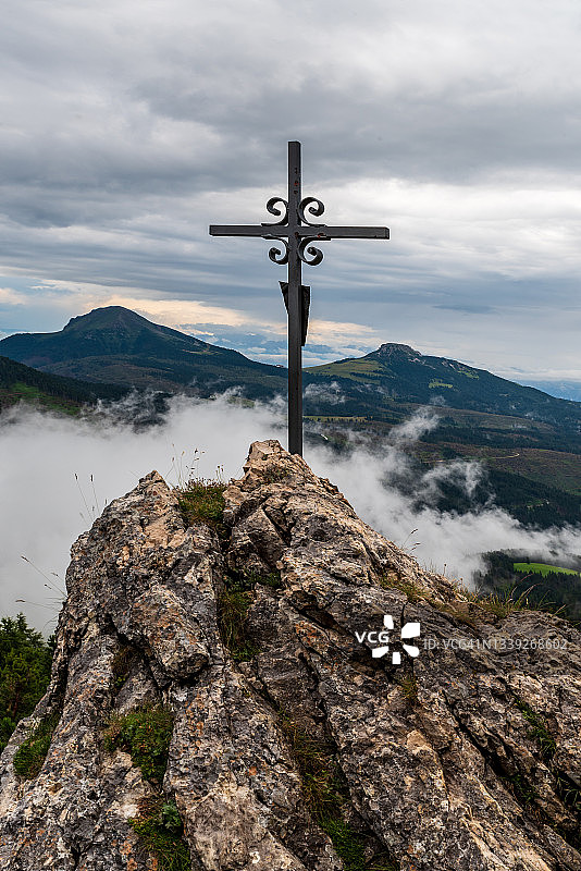 山顶十字架岩层，背景是意大利多洛米蒂山脉拉特马尔山群的奥伯霍尔茨小屋图片素材