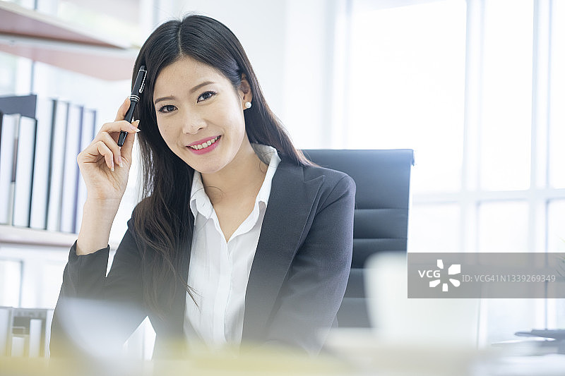 年轻的亚洲女商人在办公桌前图片素材