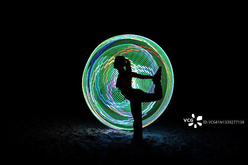 夜晚玩灯光杂耍的跳舞女子图片素材