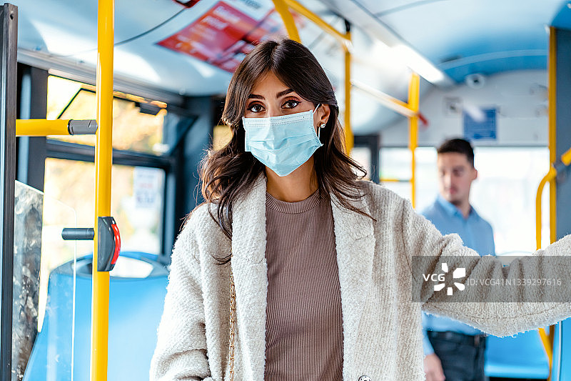 中年妇女在公共交通工具上戴着外科防护口罩图片素材