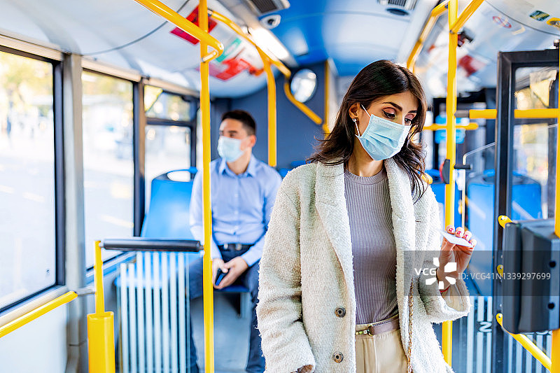 中年妇女在有轨电车或公共汽车上验证车票图片素材
