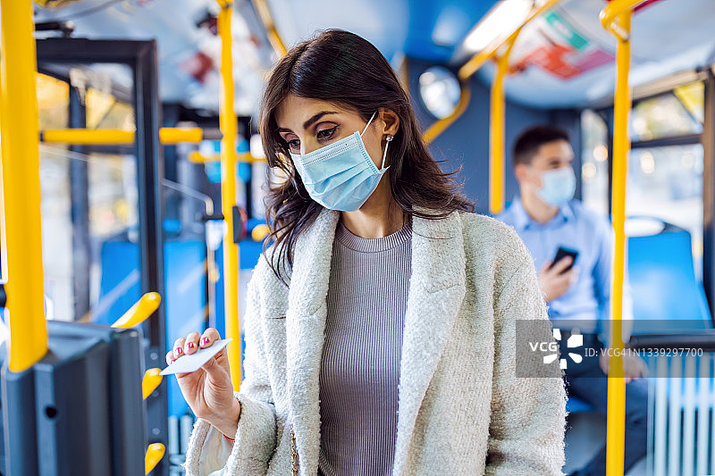 中年妇女在有轨电车或公共汽车上验证车票图片素材
