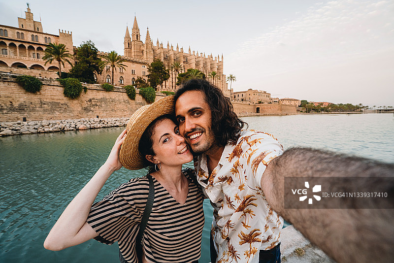 情侣在日落时分于帕尔马马约卡大教堂附近自拍图片素材