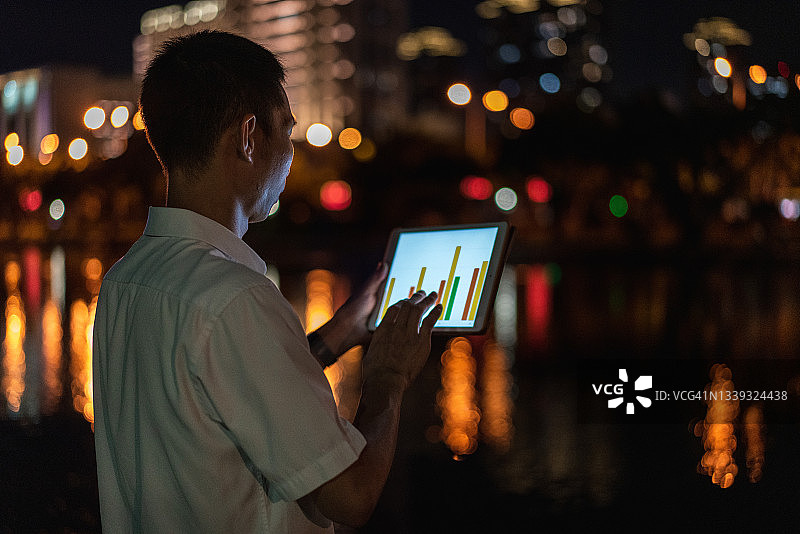 亚洲男商人用平板电脑查看数据图片素材