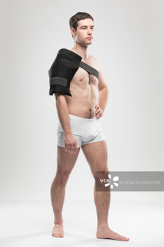 成年运动员使用可重复使用的冰袋进行伤后冰敷的证件照。康复概念，有文案空间图片素材