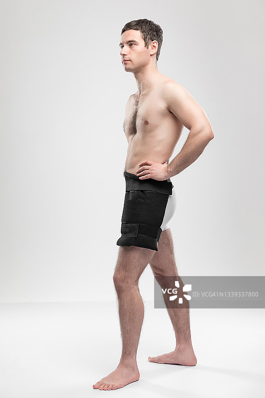 成年运动员使用可重复使用的冰袋进行伤后冰敷的证件照。康复概念，有文案空间图片素材