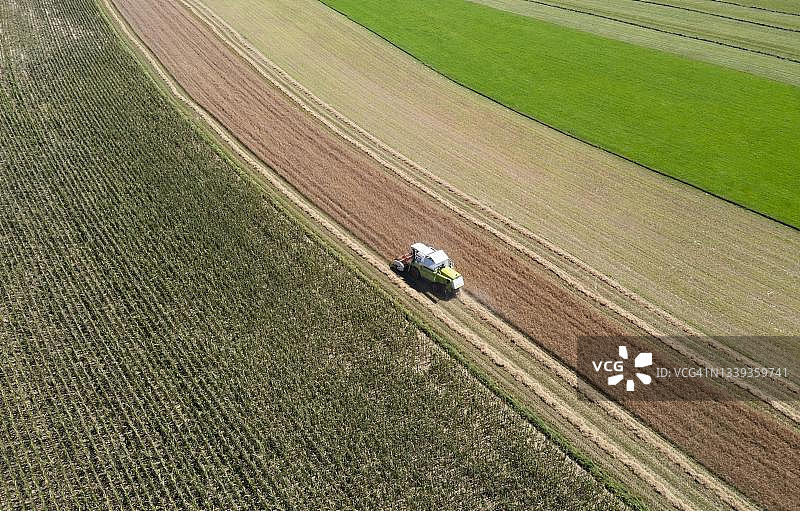 奥地利上奥地利州因维尔特尔瓦尔德采尔附近联合收割机收割谷物农业景观航拍图片素材