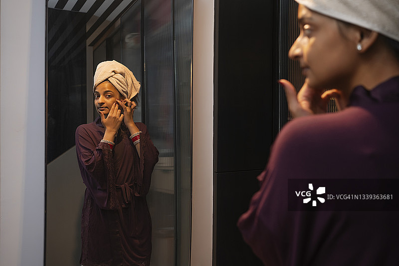 年轻新婚女子在镜子前挤痘痘图片素材