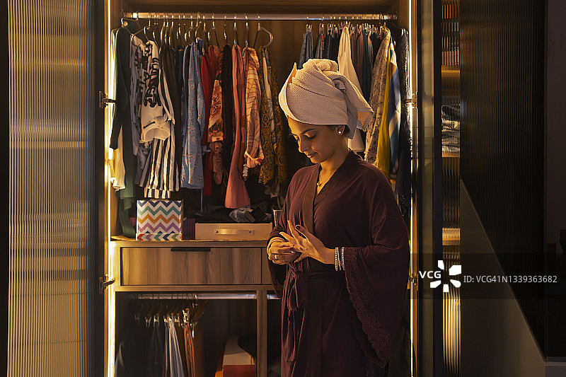 年轻新娘在衣柜前摘下戒指图片素材