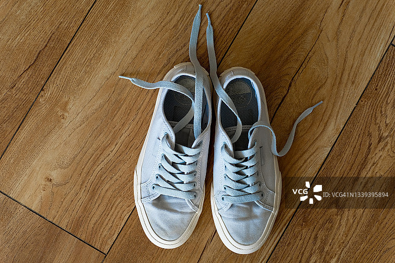 适合女性、青少年或女孩的全新干净现代运动鞋。家或室内木地板上的鞋子。时尚的生活方式。文本空间副本。图片素材