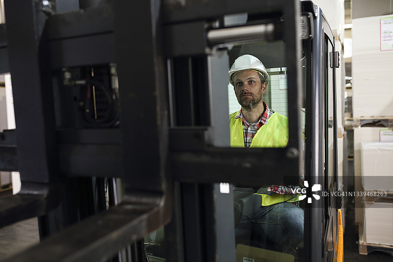 男人在仓库里驾驶叉车图片素材