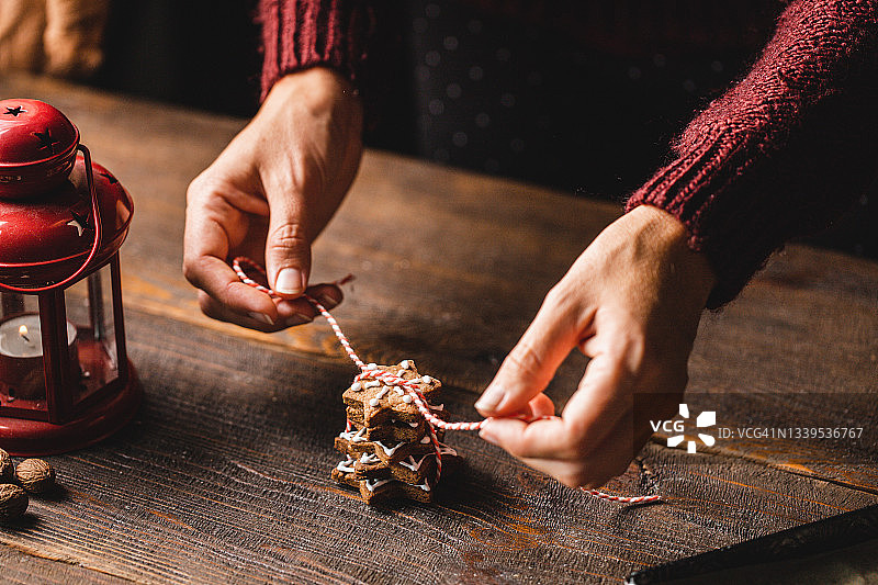 女人用绳子捆绑圣诞饼干的手图片素材