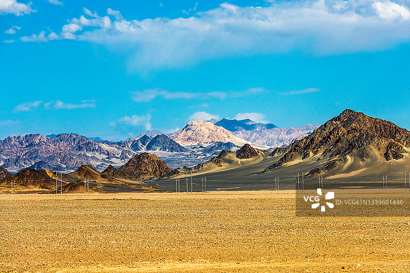 金色的沙漠，遥远的山脉。中国新疆维吾尔自治区。图片素材