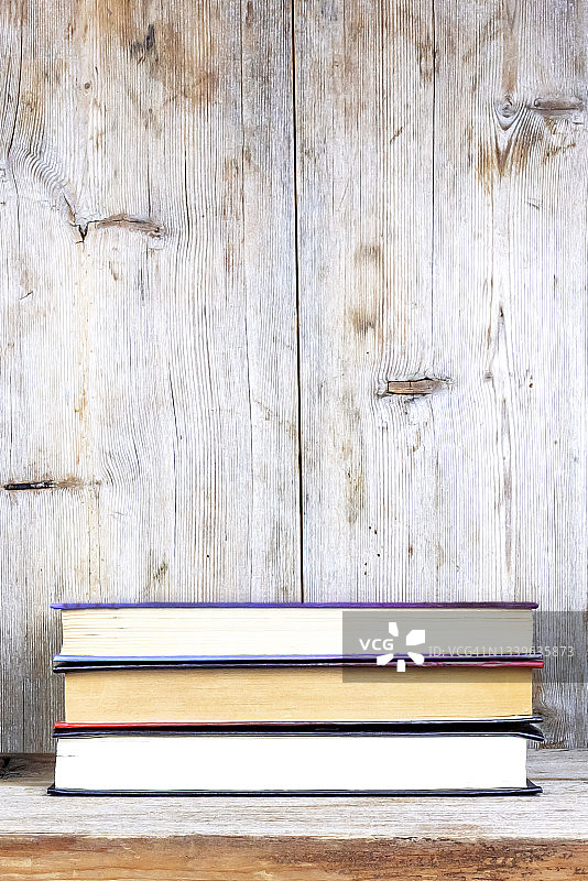 放在古朴木架上的三本旧书图片素材