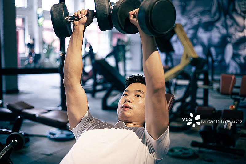 男人在健身房举哑铃图片素材
