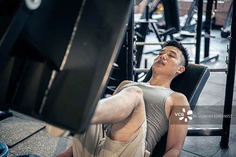 男子在健身房做腿部推举图片素材