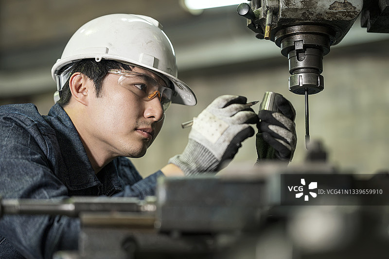 工业工程师操作精密钻孔机进行质检图片素材