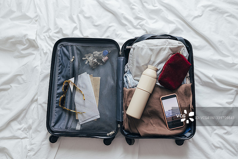 从上方看，床上放着一个打包好的行李箱，适合度假或出差图片素材