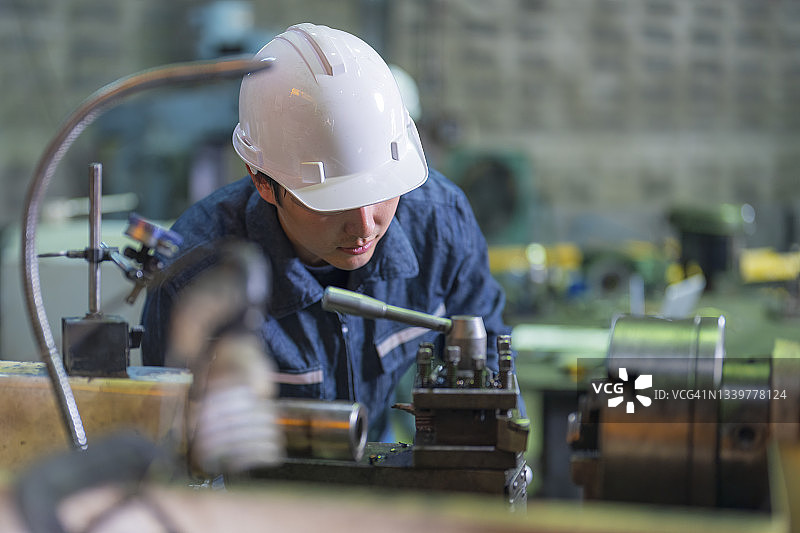 在工厂车间使用传统车床的男人图片素材