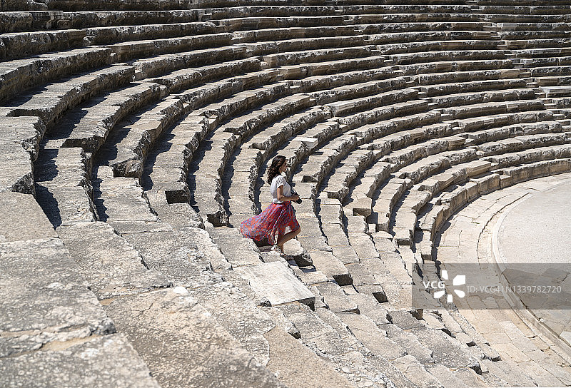 在土耳其安塔利亚阿斯潘多斯圆形剧场拍照的女性游客摄影师图片素材