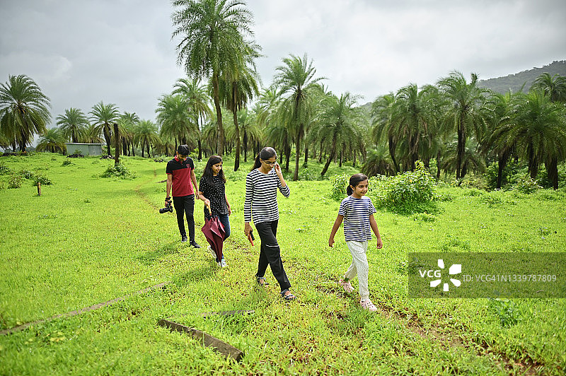 一家人在棕榈树环绕的自然环境中散步图片素材