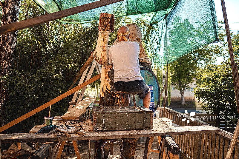 制作维京武士木雕的年长艺术家图片素材