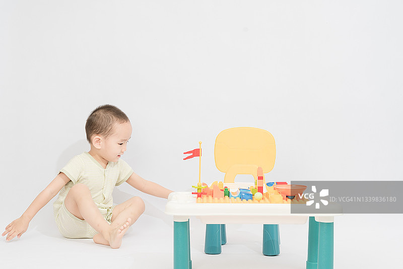 亚洲男孩在玩具桌上玩积木图片素材